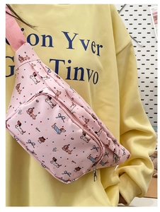 Detailed view of pink cartoon dachshund print chest bag worn on a yellow hoodie