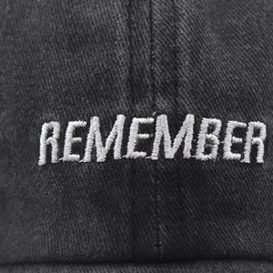 Black washed cotton baseball cap with white 3D embroidery featuring REMEMBER text