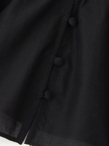 Detailed macro view of fabric texture and vertical fabric-covered buttons on black shirt