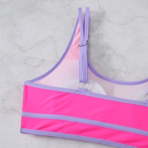 Detail view of pink bikini top with purple trim, adjustable straps, and removable pads
