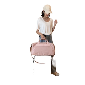 Pink large fitness bag with wet-dry separation shown on a suitcase handle