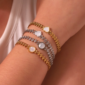 Dettaglio di bracciali in madreperla a forma di cuore con placcatura oro e argento