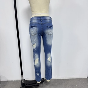 Détail arrière du jean en denim bleu avec trous usés et finition délavée vintage