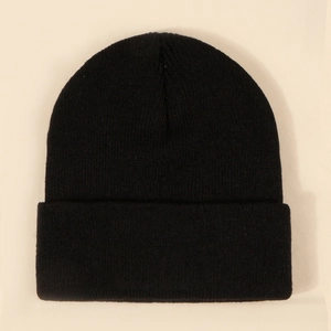 Close-up detail of the black knitted beanie with vertical ribbed texture and folded cuff