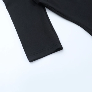 Gros plan de la double couture sur l'ourlet en tricot noir et les détails de la manche