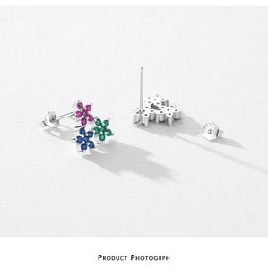Macro shot of S925 silver flower earrings with pink, blue, and green gemstones