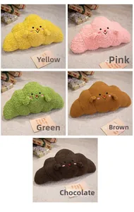 Detailed view of plush croissant pillows in yellow, pink, green, brown, and chocolate