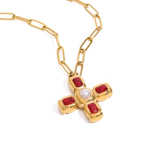 Collier croix dorée avec pierres rouges et perle centrale sur une chaîne trombone