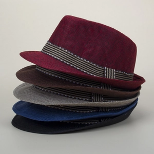 Close-up of woven straw fedora hats in multiple colors with striped ribbon trim