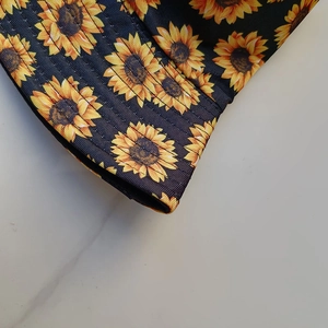 Close-up of yellow sunflower pattern on black fabric with clear stitching detail