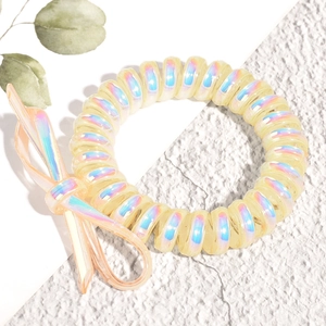 Gros plan sur un élastique spirale jaune irisé avec un nœud décoratif assorti