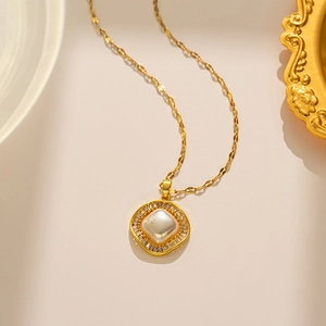 Detail view of a 18k gold square titanium steel necklace with white shell and zircon accents