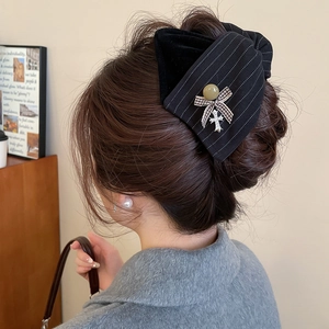 Detailaufnahme einer Vintage Haarspange mit schwarzer Schleife und Kreuzanhänger