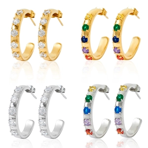 Close-up of C-shaped stainless steel hoop earrings with clear and multicolor crystals