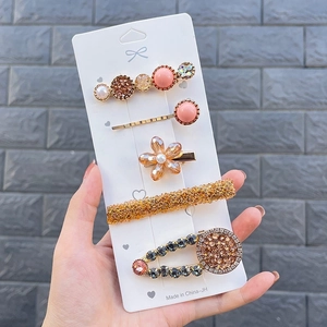 Close-up of five-piece candy-colored hair clip set with pearls and rhinestones on card