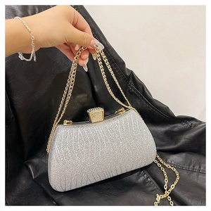 Silver glitter evening clutch bag with crystal buckle and gold chain strap detail