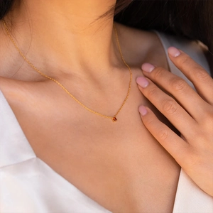 18K gold plated stainless steel birthstone necklace with orange zircon on model