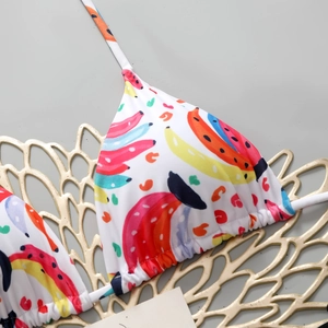 Detail view of triangle bikini top with colorful banana print and white ties