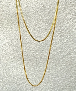 Vertical view of a layered golden titanium steel snake chain necklace for women