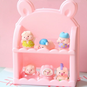 Pink tiered display rack holding various cute miniature resin pig figurines in a macro view