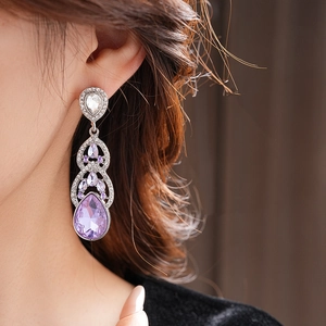 Gros plan d'une boucle d'oreille goutte en cristal violet avec tige en argent