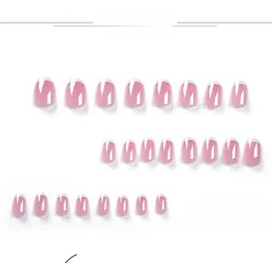 Detail view of oval French press-on nails set with pink base and white tips