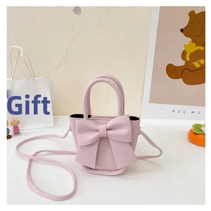 Detailed view of pink crossbody bag featuring a large bow and premium matte leather texture