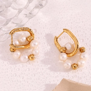 Gros plan de boucles d'oreilles créoles en acier doré avec perles d'eau douce blanches