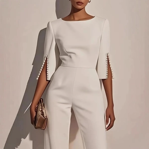 Elegante tuta bianca da donna con decorazione di perle sulle maniche e taglio aderente