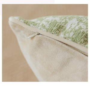 Macro shot of invisible zipper detail on cream velvet and green patterned pillow cover