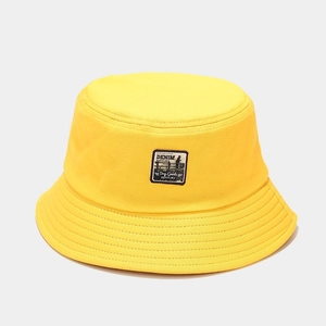 Gros plan détaillé du chapeau bob en toile jaune avec étiquette vintage et surpiqûres