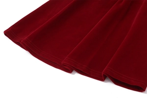 Vista detallada de la tela de terciopelo rojo oscuro y dobladillo del vestido en A
