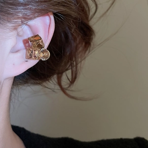 Detail of gold-plated champagne crystal ear cuff with geometric facets worn on model