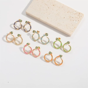 Macro detail of snake hoop earrings with colorful enamel and sparkling crystal inlay