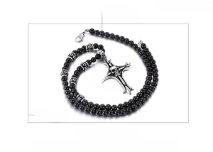 Detail of gothic stainless steel skull cross pendant with black glass beaded chain necklace