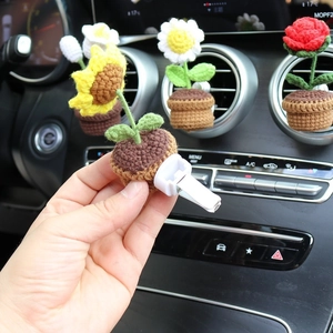 Handmade crochet sunflower car air vent clip accessory in a small woven brown pot