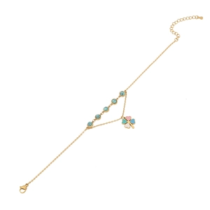 Gold anklet with turquoise beads and a colorful clover charm on a white background