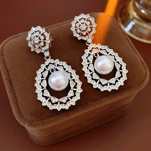 Close-up of vintage floral hollow earrings with pearls and zircon in a jewelry box