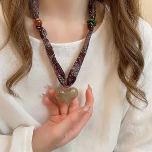 Boho cloth cord necklace with brown marble acrylic heart pendant on white linen shirt