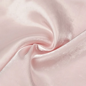 Detail of light pink satin fabric with a high-gloss finish and smooth silk-like texture