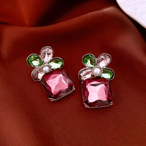 Detail of flower-shaped stud with magenta square gemstone pendant and pearl inlay