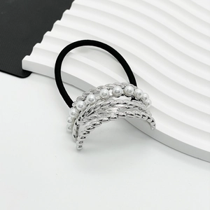 Detailed shot of silver twisted metal hair tie with inlaid white pearls on black band