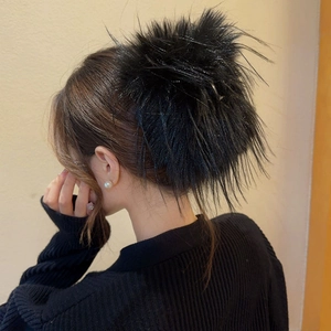 Détail d'une grande pince à cheveux en fausse fourrure noire sur l'arrière de la tête