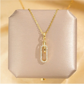 Gros plan du pendentif doré avec double anneau géométrique serti de zircons cubiques