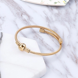 Macro shot of twisted wire gold bracelet featuring a center ball and textured details