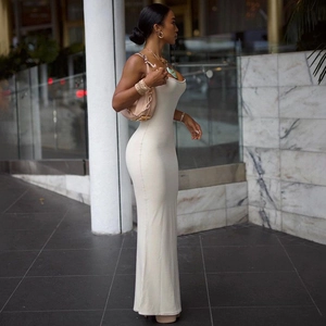 Detail of white slim-fit backless knitted maxi dress on a model in modern setting