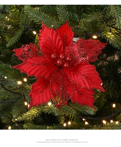 Close-up of red Christmas artificial flower with glitter sequins on a pine tree
