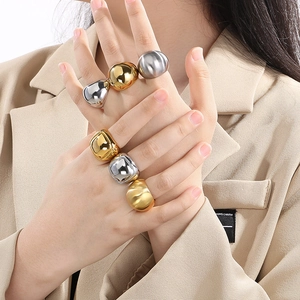 Poliert klobige Statement-Ringe in Gold und Silber am Model in minimalistischem Stil
