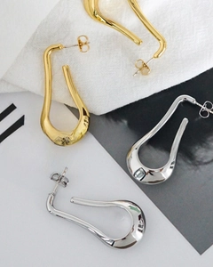 Detailed view of minimalist U-shape teardrop earrings in polished gold and silver finish