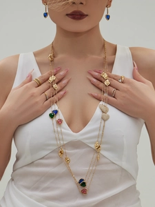 Detail of gold layered heart necklace and earrings set with vibrant multi-color stones